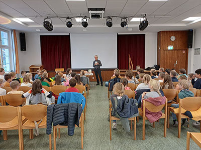 Schüler*innen im Theaterraum bei der Autorenlesung.